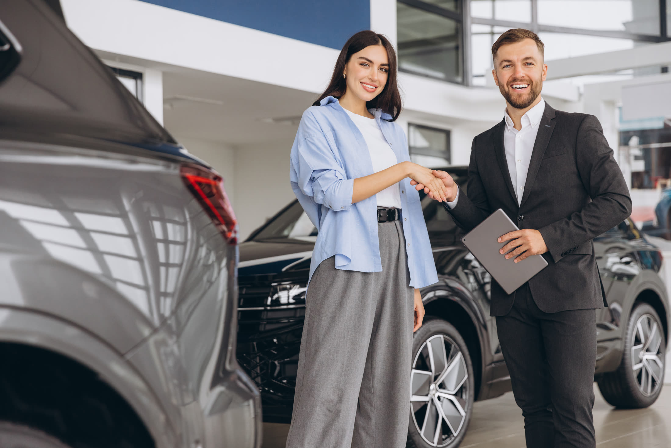 Consultant GO Cars strângând mâna unui client în showroom